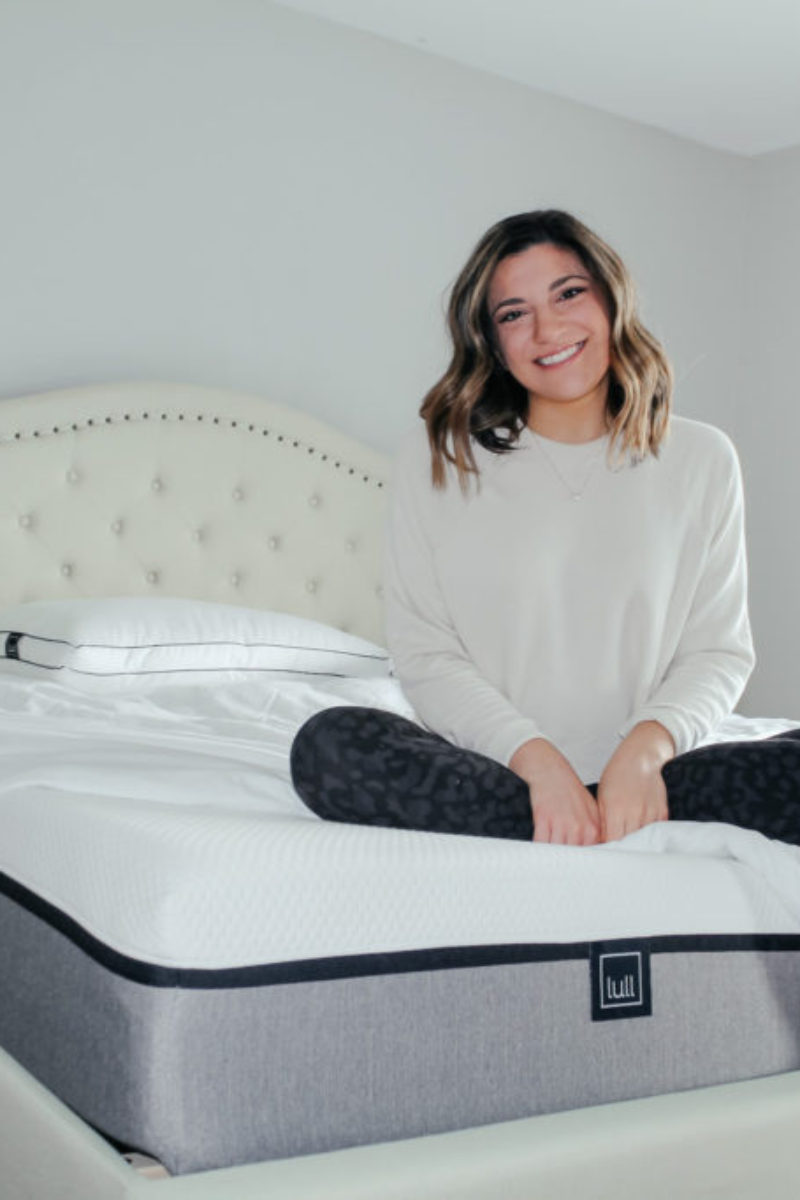 Kristen sitting on bed
